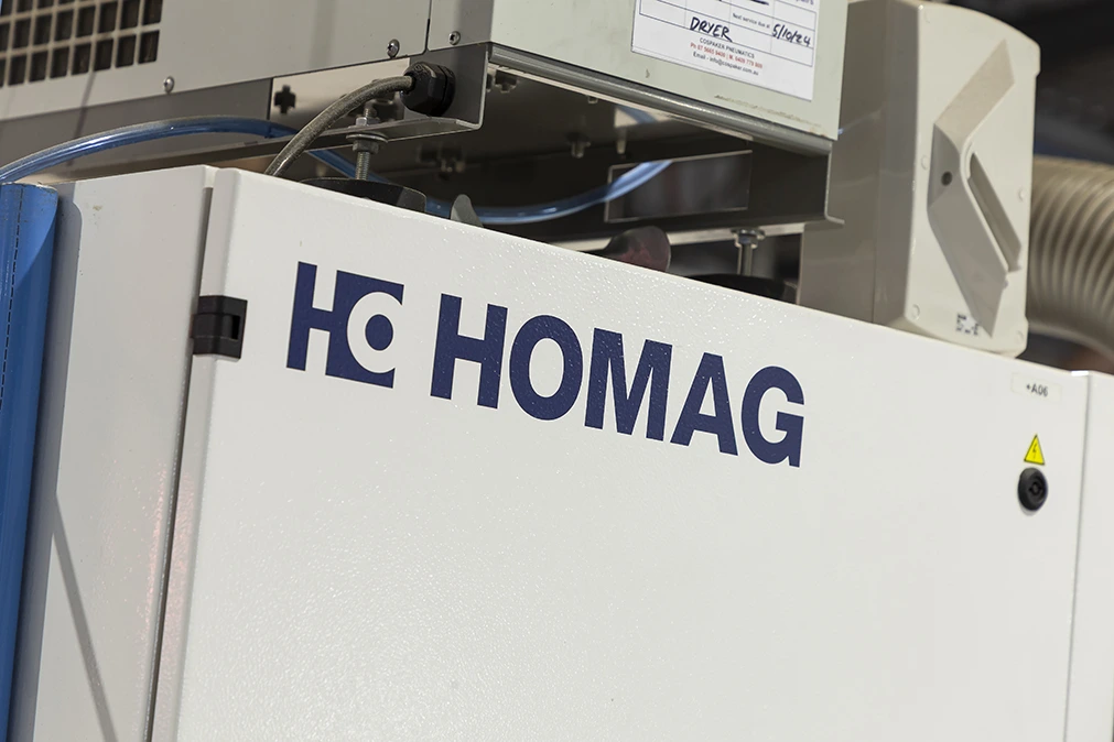 Operator aligning cabinetry panels for edge processing in HOMAG KAL310